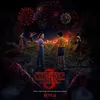 Children and teenagers stand on a hill overlooking a town at night, with fireworks in the sky. The Stranger Things 3 logo is prominent. Anteprima dell’immagine prodotto