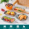 A collection of ceramic plates and bowls with a bohemian pattern, set on a table with food. Náhled obrázku produktu