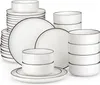 A collection of white ceramic plates and bowls with black trim, neatly stacked and arranged. Náhled obrázku produktu