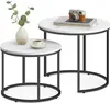 Two nesting round coffee tables with marble-look tops and black metal legs, one with a vase of greenery and a cup of coffee, the other with a stack of books and a vintage camera. Produktbild-Vorschau