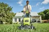 A man is mowing the lawn in front of a house on a sunny day. Produktbild-Vorschau