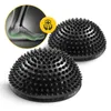 Two black spiky massage balls with an inset graphic showing a foot's anatomy. Náhled obrázku produktu