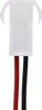 A close-up view of a white electrical connector with red and black wires attached. Produktbild-Vorschau
