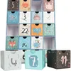 A close-up view of a blue advent calendar with 24 drawers, each decorated with animal illustrations and numbers. Some drawers are open, revealing the inside. Three individual boxes are placed in front of the calendar. Náhľad obrázku produktu