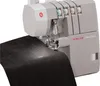 A Singer Heavy Duty overlock sewing machine is shown in operation, stitching black fabric. Náhľad obrázku produktu