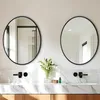 A modern bathroom vanity with two round mirrors above a marble countertop and wooden cabinets. Produktbild-Vorschau