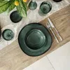 A table setting with dark green plates and cutlery. Produktbild-Vorschau