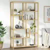 A gold-colored bookshelf with various decorative items and books displayed on its shelves, placed in a room with a sofa and artwork in the background. Produktbild-Vorschau