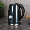 A dark blue electric kettle with a thermometer is placed on a dark countertop next to a green plant. Podgląd zdjęcia produktu