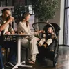 A family enjoying a moment at a cafe with a baby in a stroller. Voir les images du produit