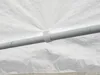 A close-up view of a white fabric tent pole with a white velcro strap holding it together. Náhled obrázku produktu