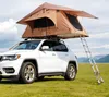 A white SUV with a rooftop tent is parked on a grassy field with mountains in the background. Anteprima dell’immagine prodotto