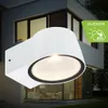 A white outdoor wall lamp is mounted on the side of a modern house. Produktbild-Vorschau