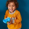A young child smiles while holding a drink bottle. Náhled obrázku produktu