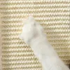A close-up view of a white cat's paw scratching a beige, woven scratching post. Produktbild-Vorschau