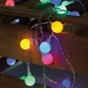 A string of colorful LED party lights is draped over wooden planks. Produktbild-Vorschau