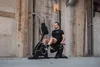 A man is exercising on a recumbent exercise bike in an industrial-looking space with brick walls. Produktbild-Vorschau
