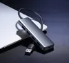 A gray USB hub splitter is placed on top of a laptop, with its USB cable connected. Produktbild-Vorschau