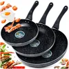Three frying pans of different sizes are arranged diagonally, with some food items like bacon, eggs, and vegetables scattered around them. Náhľad obrázku produktu