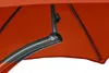 Close-up view of the underside of an orange umbrella canopy, showing the metal frame and a joint mechanism. Produktbild-Vorschau