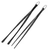 Two black kitchen tongs are displayed diagonally on a white background. Produktbild-Vorschau