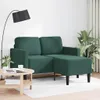 A dark green sofa with a chaise lounge is shown in a room setting with a floor lamp and a coffee table.