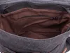 Close-up view of the interior of a dark gray canvas bag with brown lining and a zipper pocket. Podgląd zdjęcia produktu