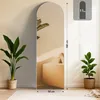 A tall, arched mirror stands against a wall, reflecting a room with furniture and plants. Dimensions and weight information are displayed. Produktbild-Vorschau