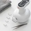 A white massage device with a gray towel and small white cubes on a white surface. Anteprima dell’immagine prodotto