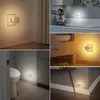 Collage of images showing LED night lights plugged into outlets in various home settings. Produktbild-Vorschau