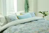 A neatly made bed with a patterned duvet cover and several pillows. Produktbild-Vorschau
