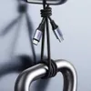 Two USB-C cables are shown hanging from a metal bar, with the brand name 'UGREEN' visible on the connectors. Náhled obrázku produktu