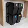 Four black plastic trash bins are stacked in two columns of two, placed under a wooden countertop. Podgląd zdjęcia produktu
