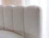 A close-up view of a textured, cream-colored headboard with vertical channel tufting. Produktbild-Vorschau