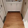 A hallway with wood-look flooring and white cabinets. Anteprima dell’immagine prodotto