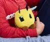 A person holding a Minecraft bee plush toy. Podgląd zdjęcia produktu