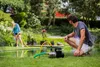 A man and a woman are in a garden near a pond, with a water pump set up on the grass. Produktbild-Vorschau