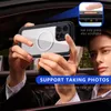 A person is holding a phone with a protective case inside a car. Produktbild-Vorschau