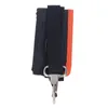 A close-up view of a black and orange strap with a metal clip, likely an accessory for a tool. Náhled obrázku produktu