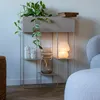 A modern shelving unit with a plant, vase, and lamp, placed in a living room setting. Náhled obrázku produktu