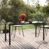 A dining table set up on a wooden deck in a garden setting. Produktbild-Vorschau