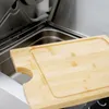 A close-up view of a wooden cutting board placed on a stainless steel grill. Produktbild-Vorschau