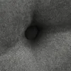 A close-up view of a tufted gray fabric cushion with a button detail. Produktbild-Vorschau