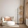 A modern living room scene featuring a circular armchair and a spiral LED floor lamp. Produktbild-Vorschau