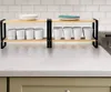 A two-tiered kitchen shelf holding plates, bowls, and cups, placed on a countertop with a tiled backsplash. Anteprima dell’immagine prodotto