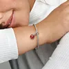 A close-up shot of a person's arm wearing a Pandora bracelet with a ladybug charm. Podgląd zdjęcia produktu