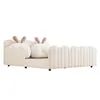 A beige upholstered bed with a cloud-shaped headboard and bunny ears, shown from the side against a white background. Náhled obrázku produktu