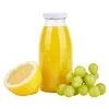 A bottle of yellow juice, a cut lemon, and a bunch of green grapes on a white background. Podgląd zdjęcia produktu