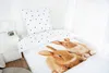 A bed with a duvet cover featuring a rabbit print and a pillow with a polka dot pattern. Anteprima dell’immagine prodotto
