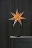 A star-shaped lamp with a brass stand is placed on a marble surface against a dark gray curtain. Podgląd zdjęcia produktu